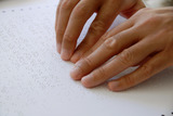 Photograph: two hands reading Braille